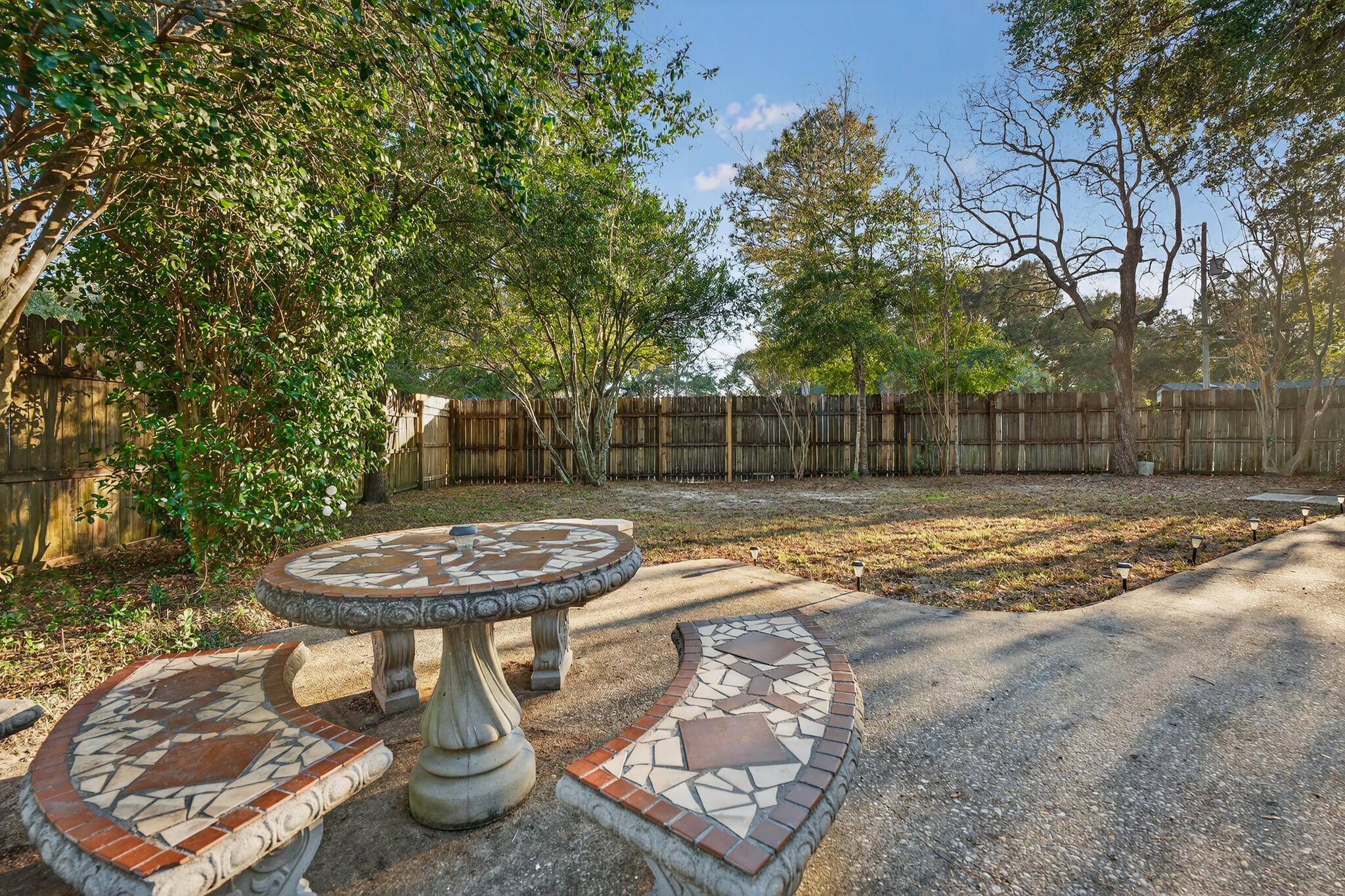 420 Paradise Road Niceville, FL 32578 - Photo 30 of 38 a view of a backyard with table and chairs and a fire pit