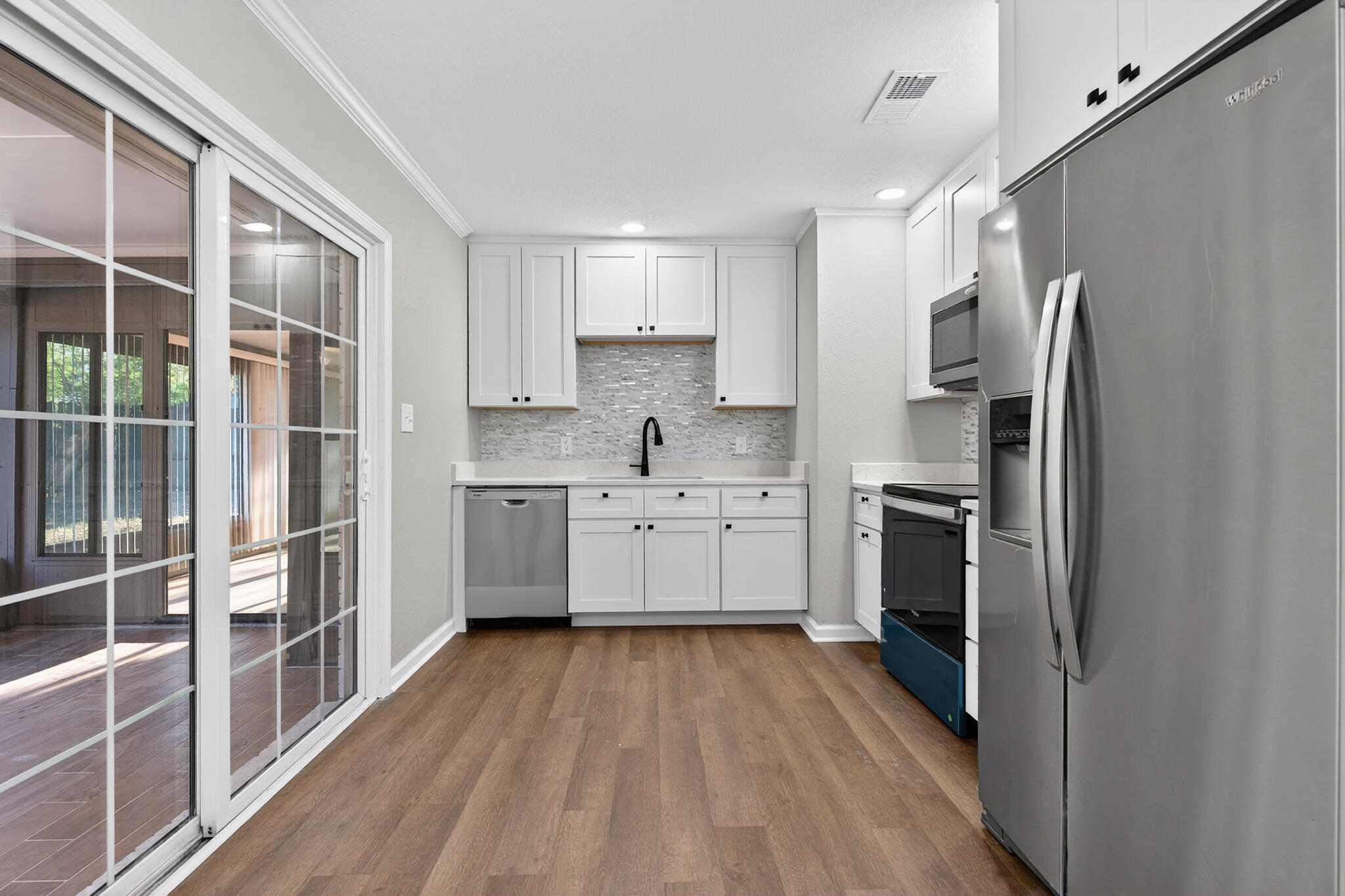 420 Paradise Road Niceville, FL 32578 - Photo 5 of 38 a kitchen with white cabinets and stainless steel appliances