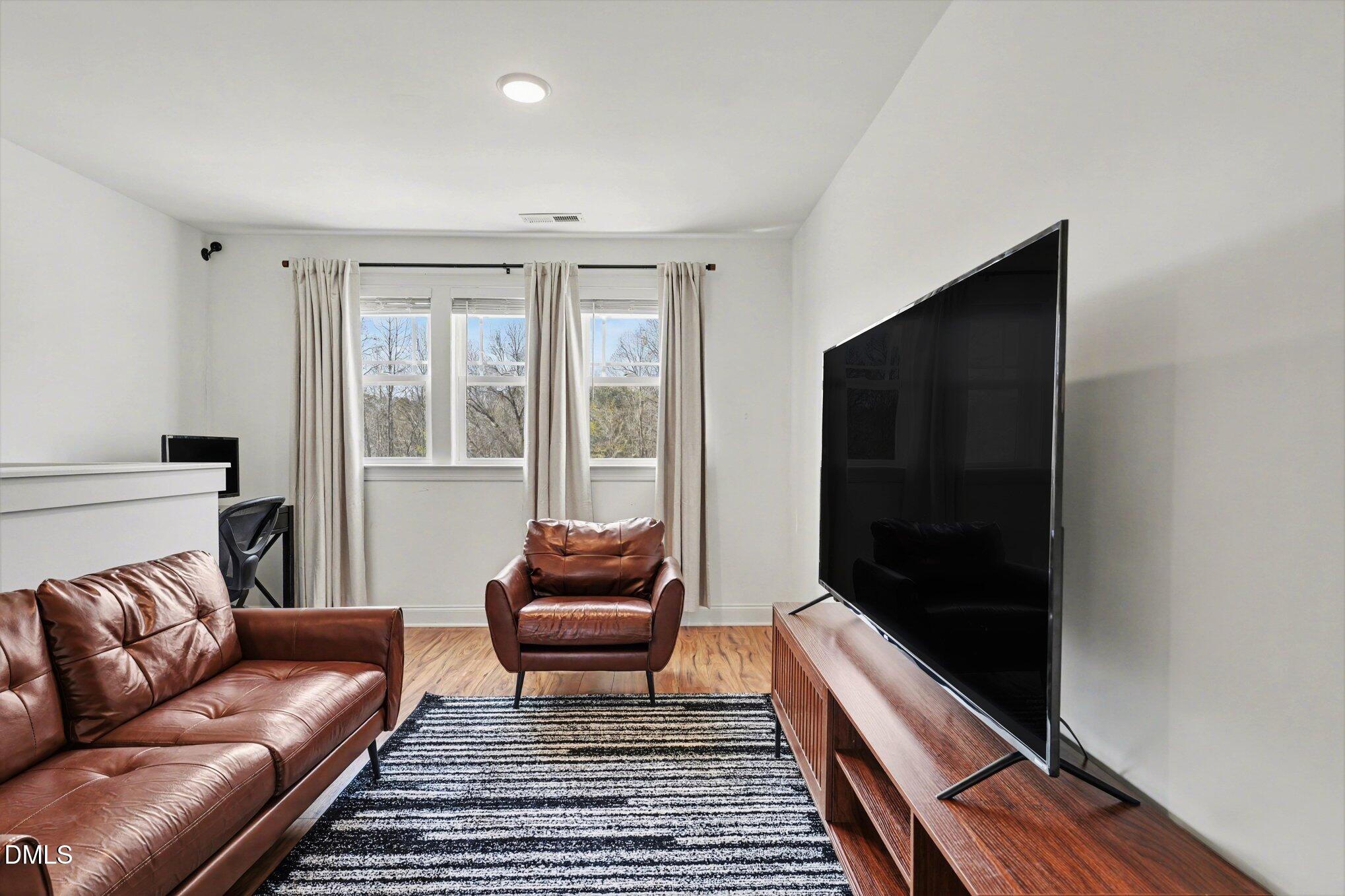 209 Timber Wolf Crossing Garner, NC 27529 - Photo 8 of 38 a living room with furniture and a flat screen tv