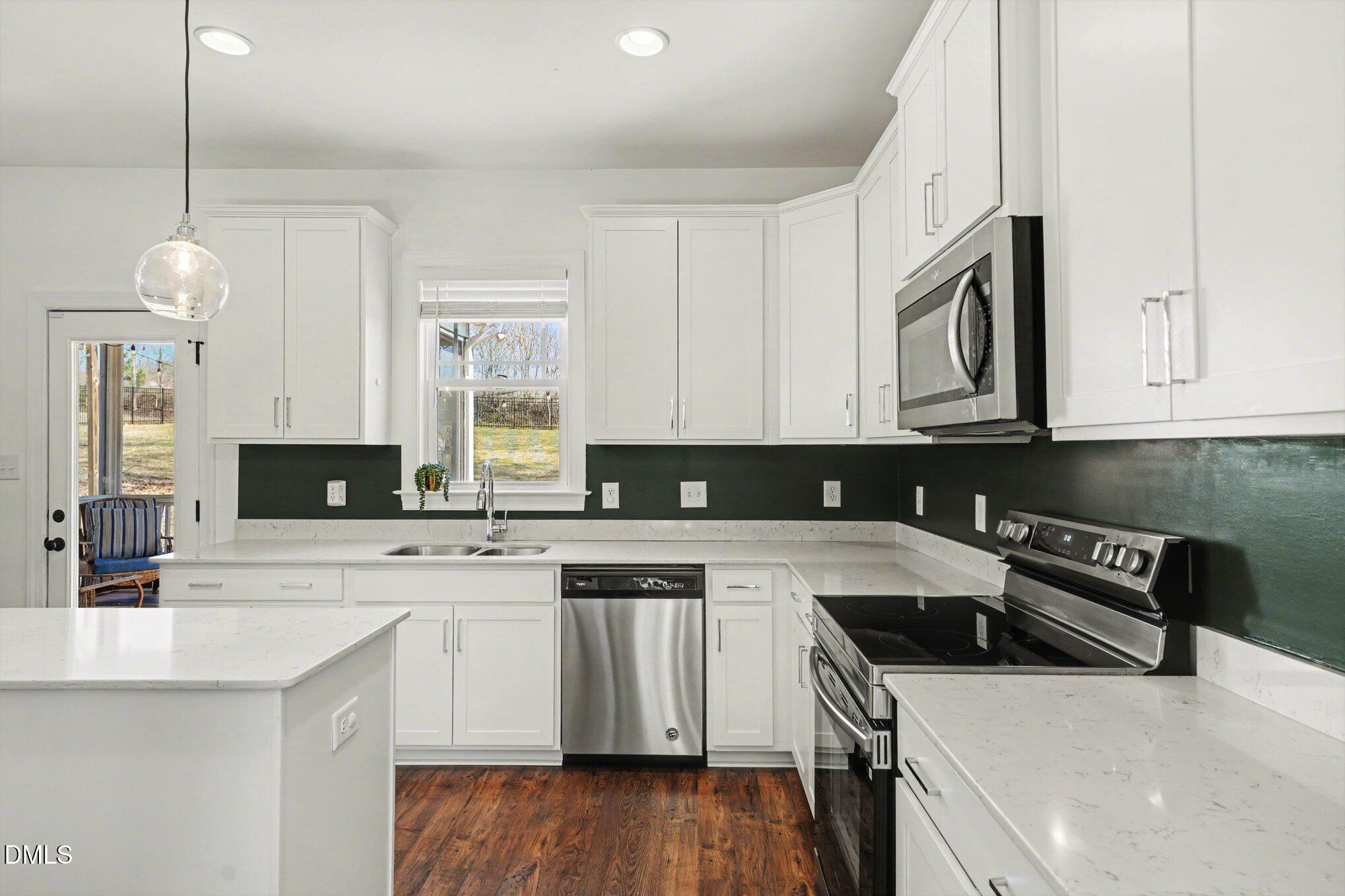 209 Timber Wolf Crossing Garner, NC 27529 - Photo 13 of 38 a kitchen with stainless steel appliances granite countertop a sink a stove a microwave and cabinets