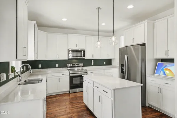 a kitchen with stainless steel appliances granite countertop a sink a stove a microwave and cabinets