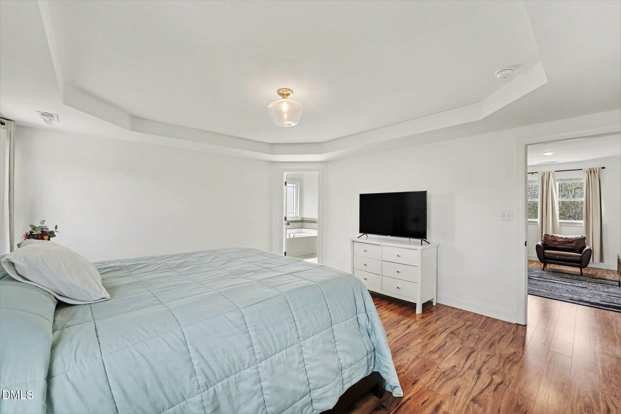209 Timber Wolf Crossing Garner, NC 27529 - Photo 17 of 38 a bedroom with a bed and a flat screen tv