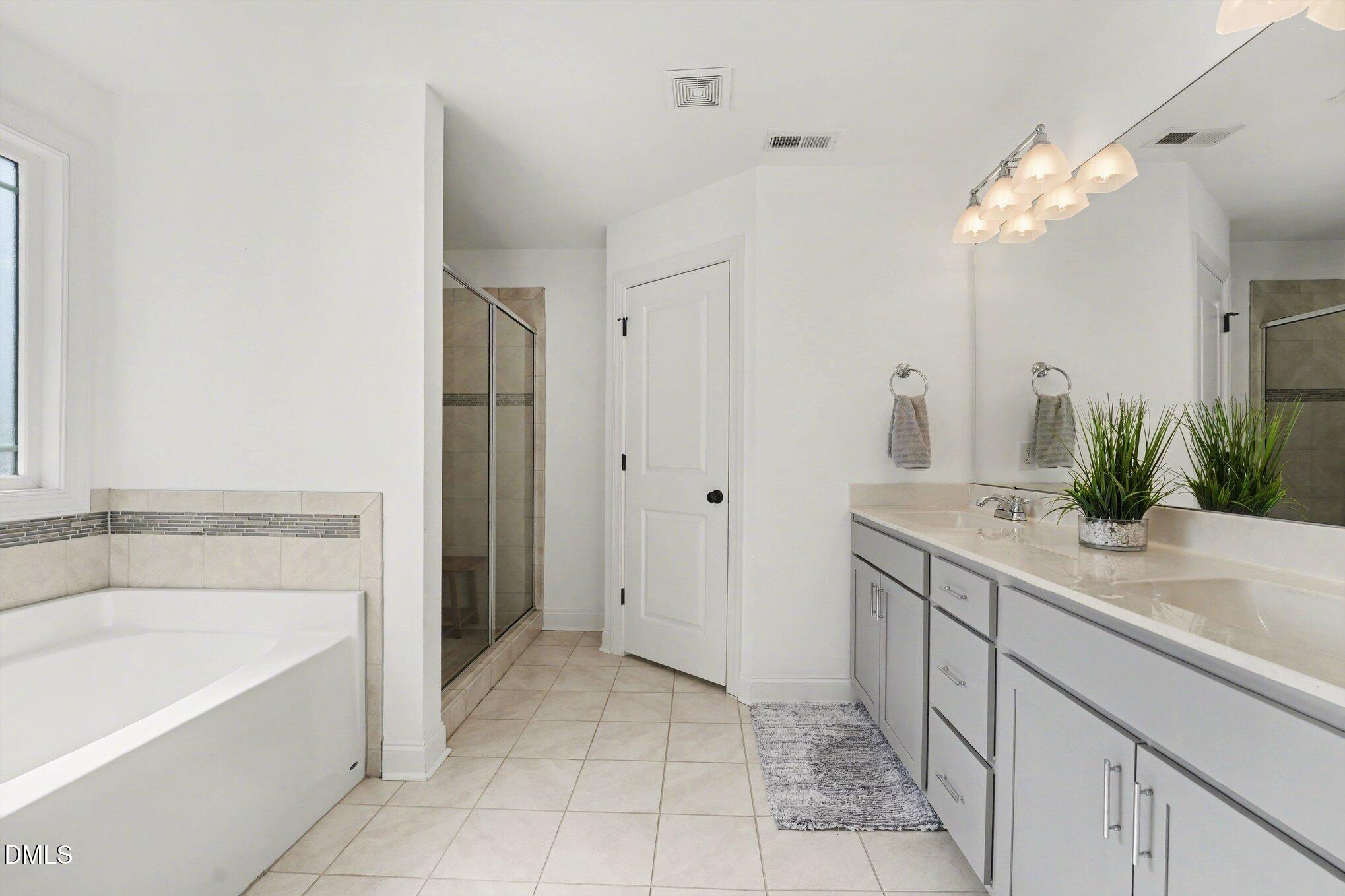 209 Timber Wolf Crossing Garner, NC 27529 - Photo 19 of 38 a bathroom with a tub sink and a mirror