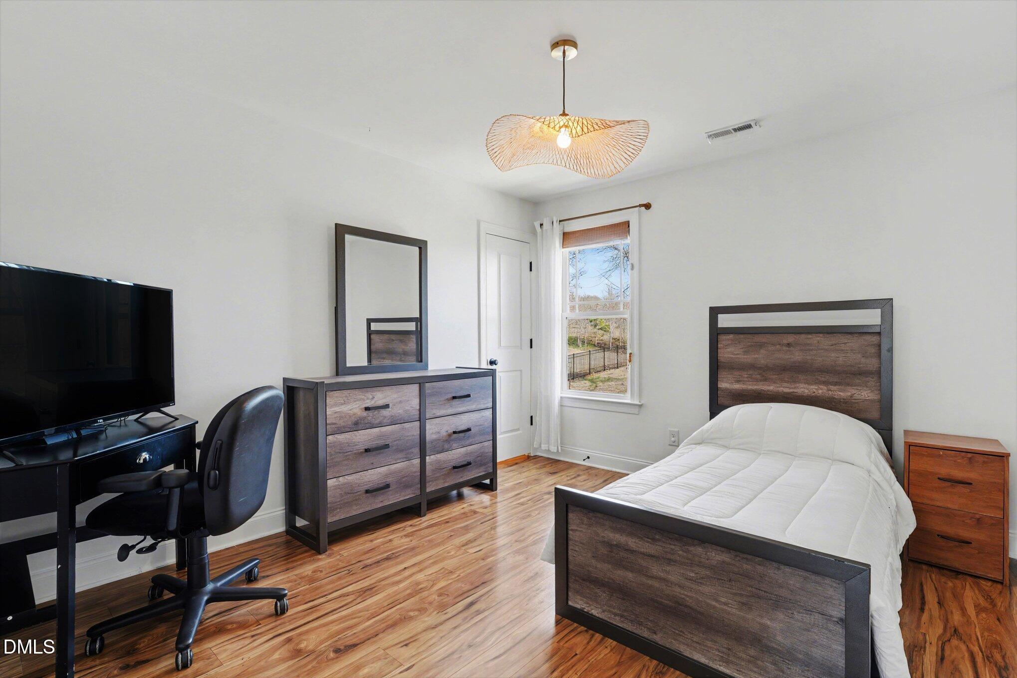 209 Timber Wolf Crossing Garner, NC 27529 - Photo 23 of 38 a bedroom with a bed and a flat screen tv