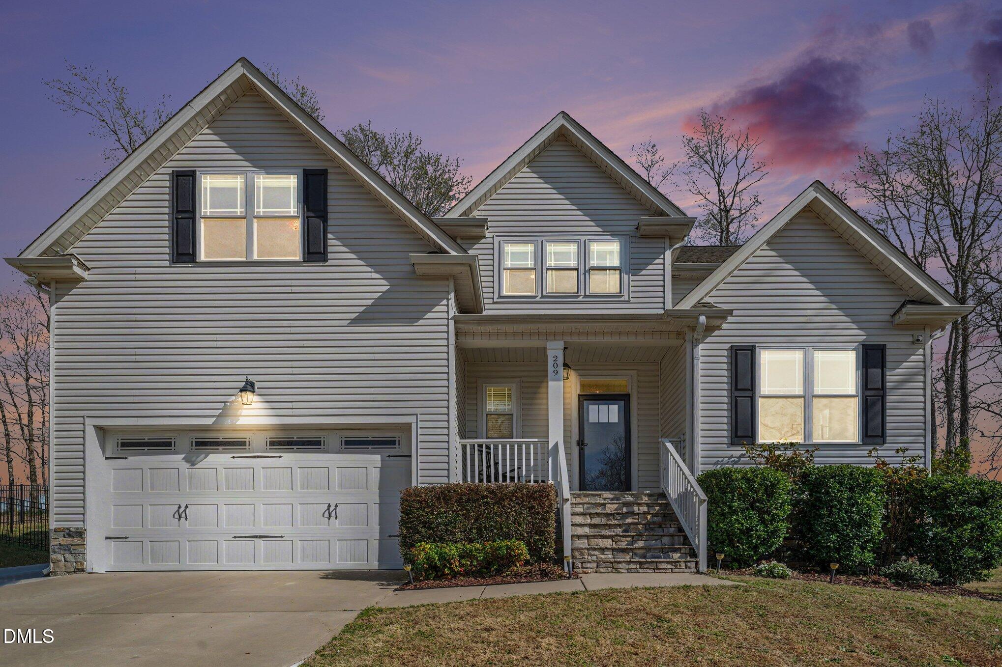 209 Timber Wolf Crossing Garner, NC 27529 - Photo 2 of 38 a front view of a house with a yard and garage