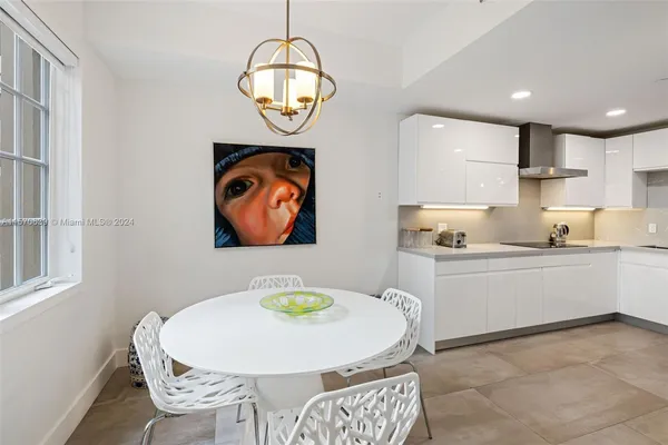 a kitchen with stainless steel appliances kitchen island granite countertop a table chairs and wooden floor