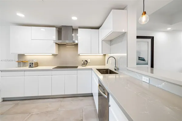 a kitchen with granite countertop a sink a stove and cabinets