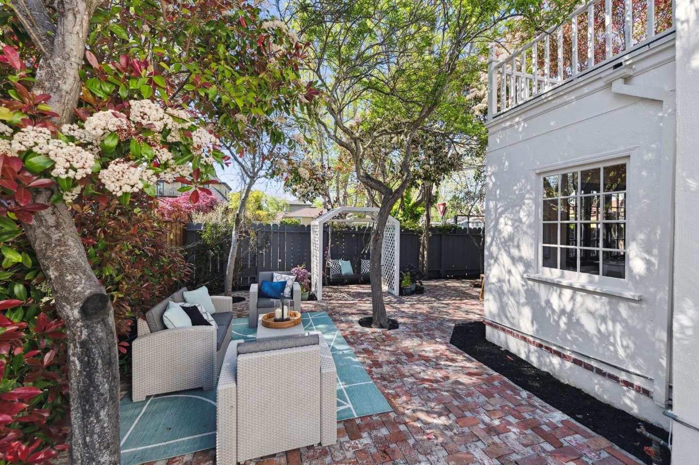 321 Bloomfield Road Burlingame, CA 94010 - Photo 34 of 45 a view of a patio with couches and chairs under an umbrella with large trees