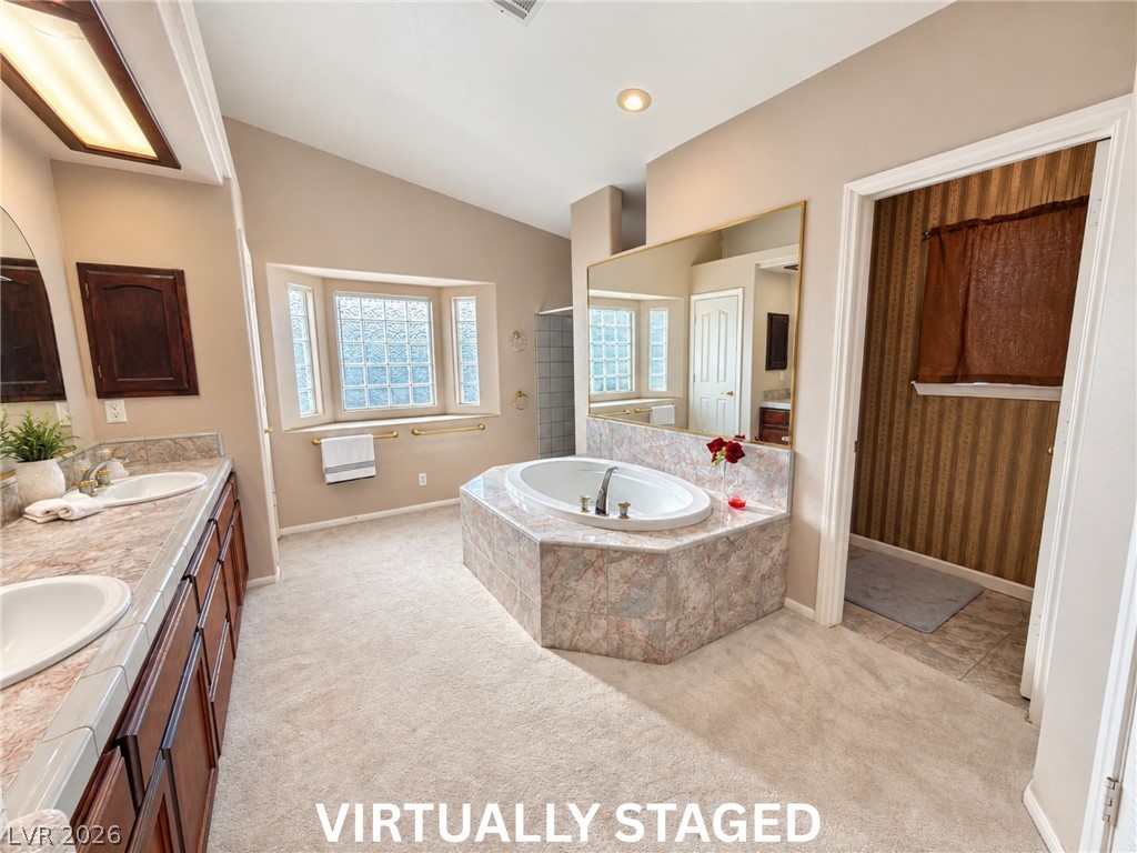 5470 Grain Mill Road Pahrump, NV 89061 - Photo 20 of 80 VIRTUALLY STAGED Angled ceilings and a tiled soaking tub create an inviting atmosphere in this main bathroom. There is also a linen closet, double sinks and a walk-in shower.