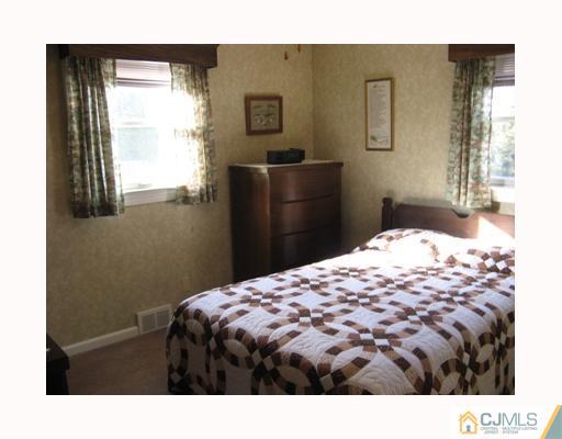 856 Ridge Road Monmouth Junction, NJ 08852 - Photo 6 of 7 a bedroom with a bed and dresser