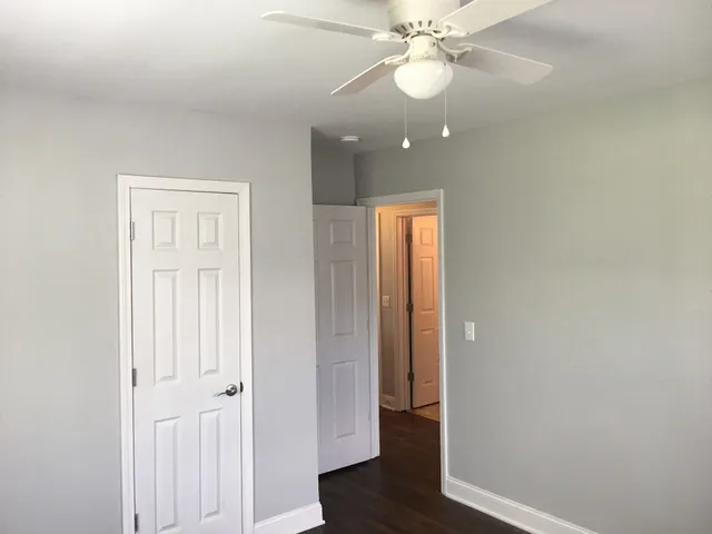 an empty room with wooden floor and hallway