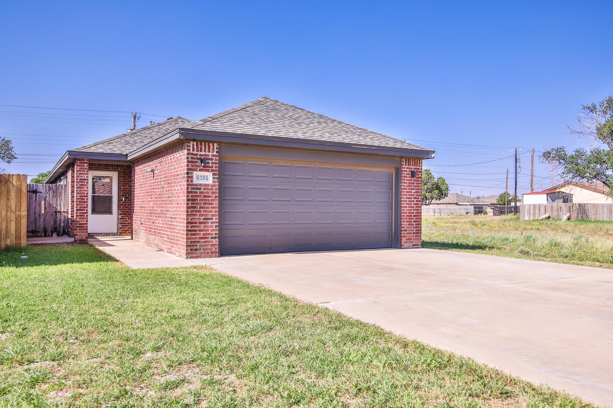 6205 21st Street Lubbock, TX 79407 - Photo 20 of 22 a front view of a house with a yard and garage