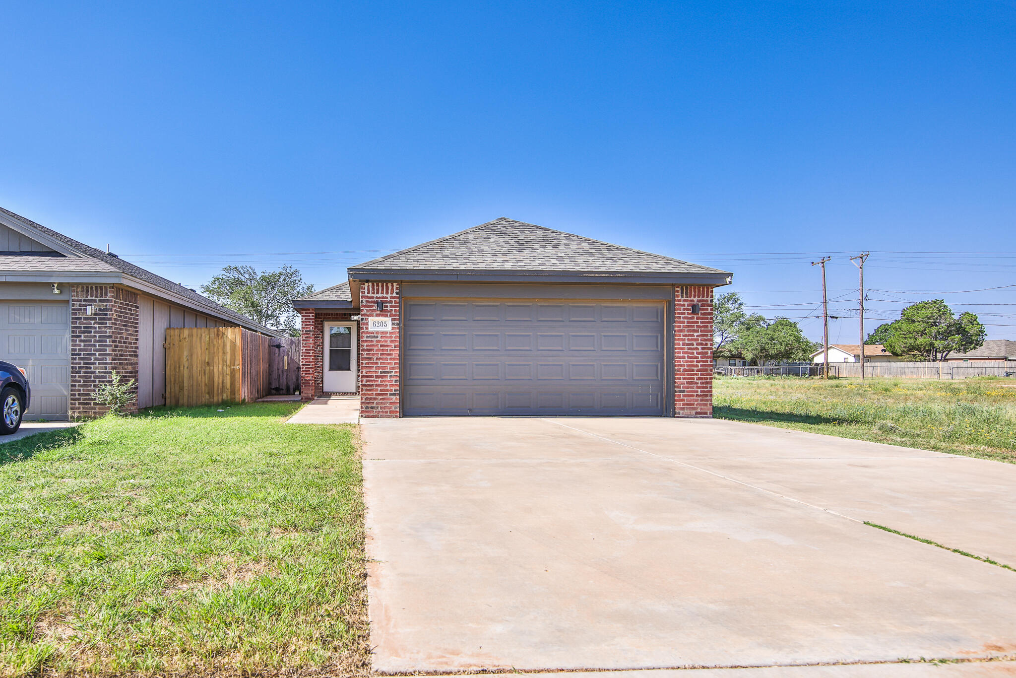 6205 21st Street Lubbock, TX 79407 - Photo 21 of 22 a front view of a house with a yard and garage