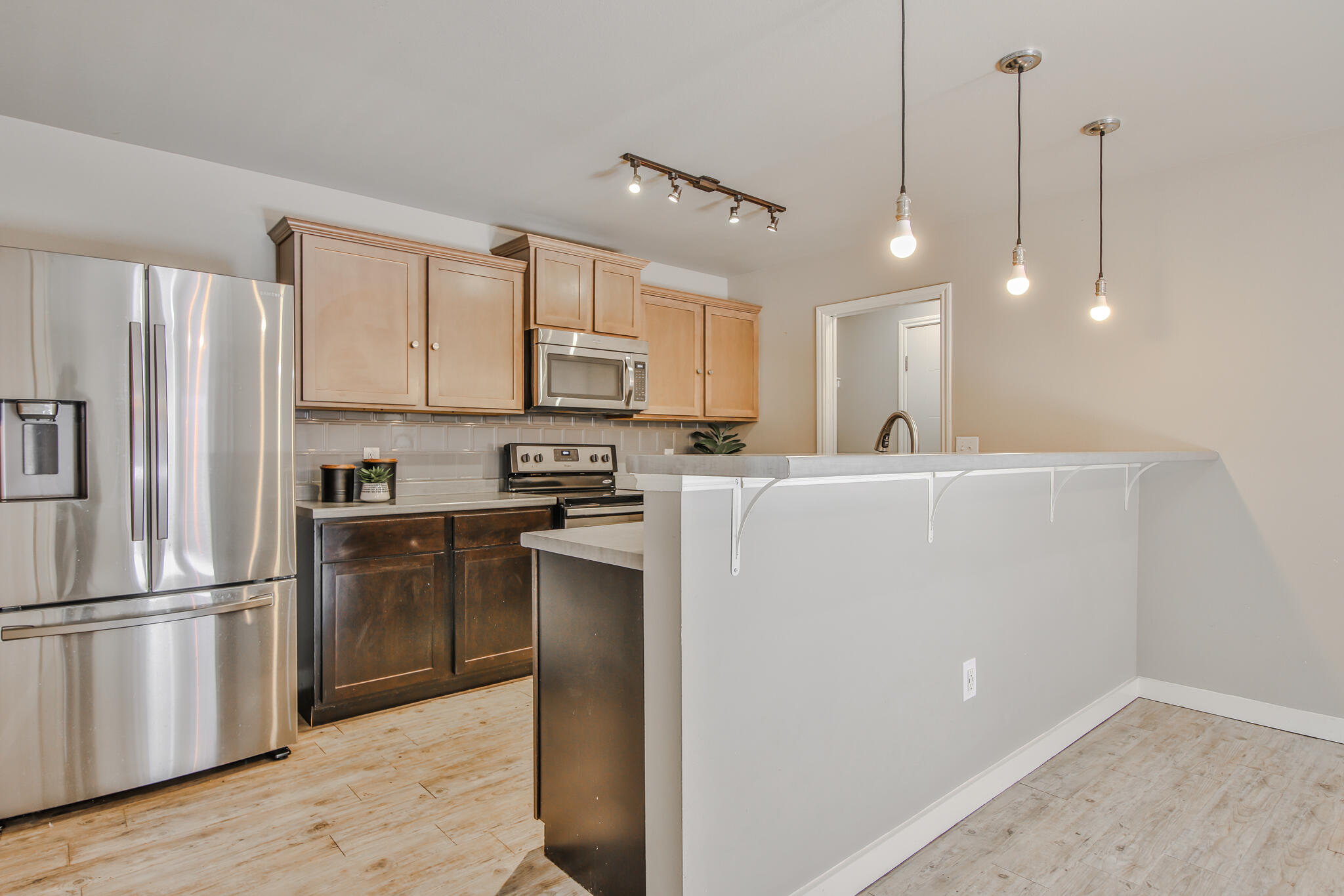 6205 21st Street Lubbock, TX 79407 - Photo 5 of 22 a kitchen with kitchen island a counter top space a refrigerator and cabinets
