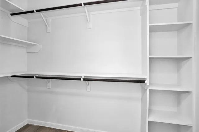 a view of walk in closet with empty racks