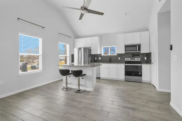 a kitchen with kitchen island a stove a sink and a microwave