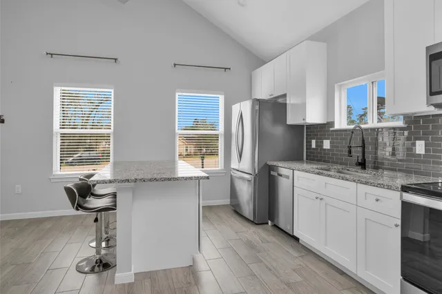 a kitchen with stainless steel appliances a refrigerator sink and cabinets