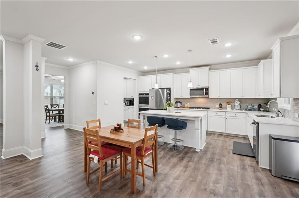 177 Treeline Trail Canton, GA 30115 - Photo 16 of 66 a open dining room with stainless steel appliances kitchen island granite countertop a stove a sink a dining table and chairs