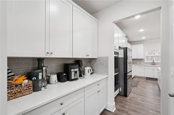 a kitchen with stainless steel appliances white cabinets and wooden floor