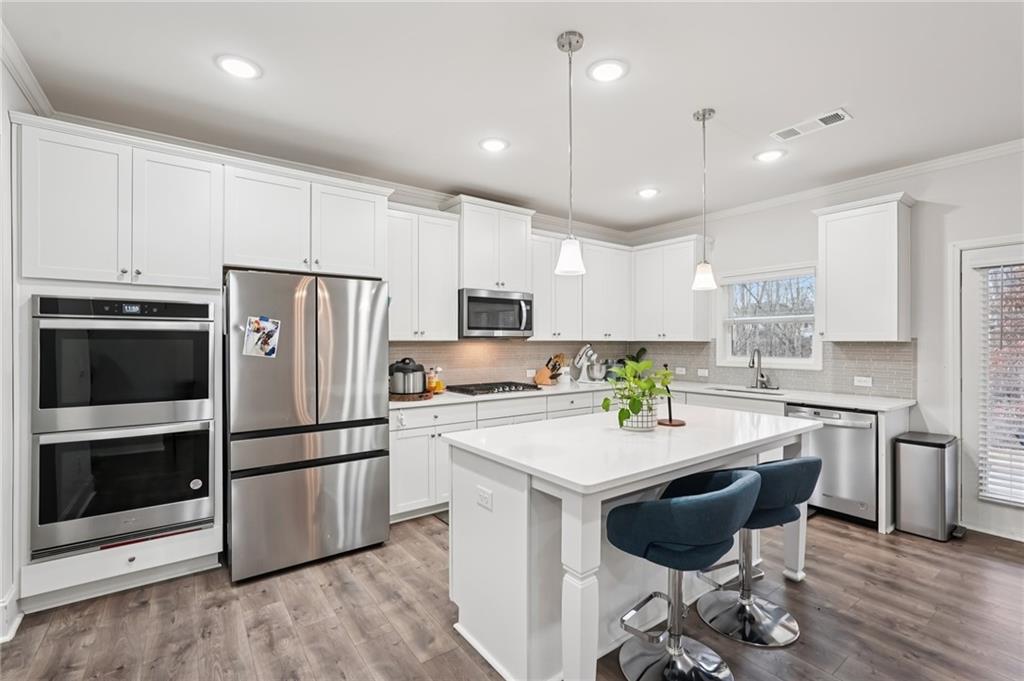 177 Treeline Trail Canton, GA 30115 - Photo 21 of 66 a kitchen with stainless steel appliances a refrigerator a stove a sink a dining table and chairs