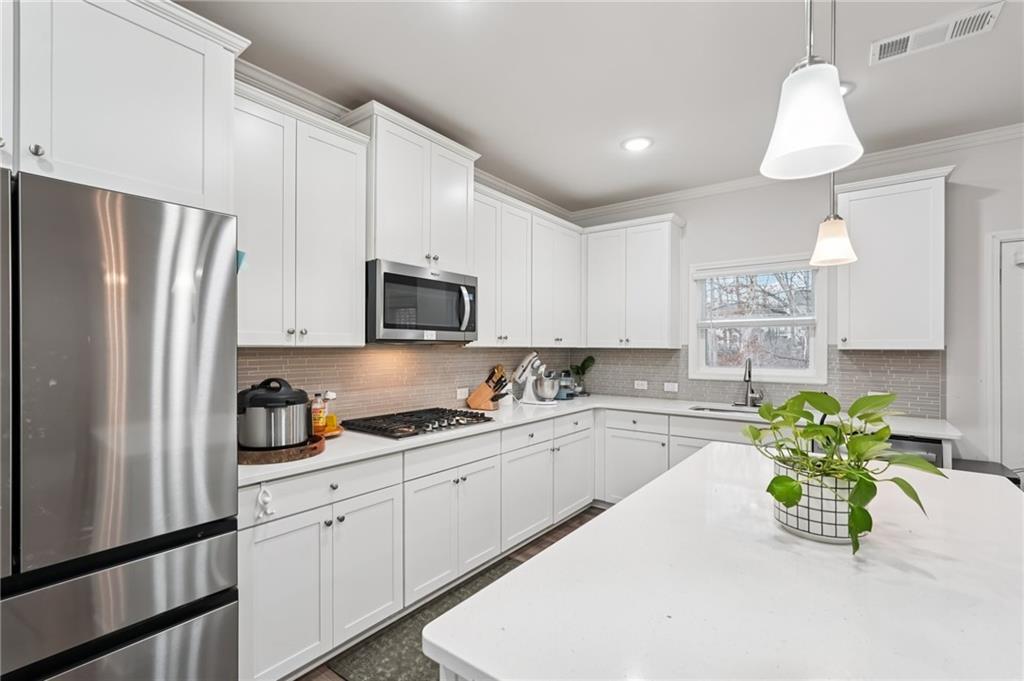 177 Treeline Trail Canton, GA 30115 - Photo 22 of 66 a kitchen with stainless steel appliances a sink a stove a refrigerator a center island and cabinets