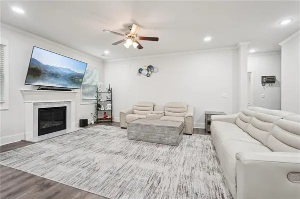 a living room with furniture kitchen view and a wooden floor
