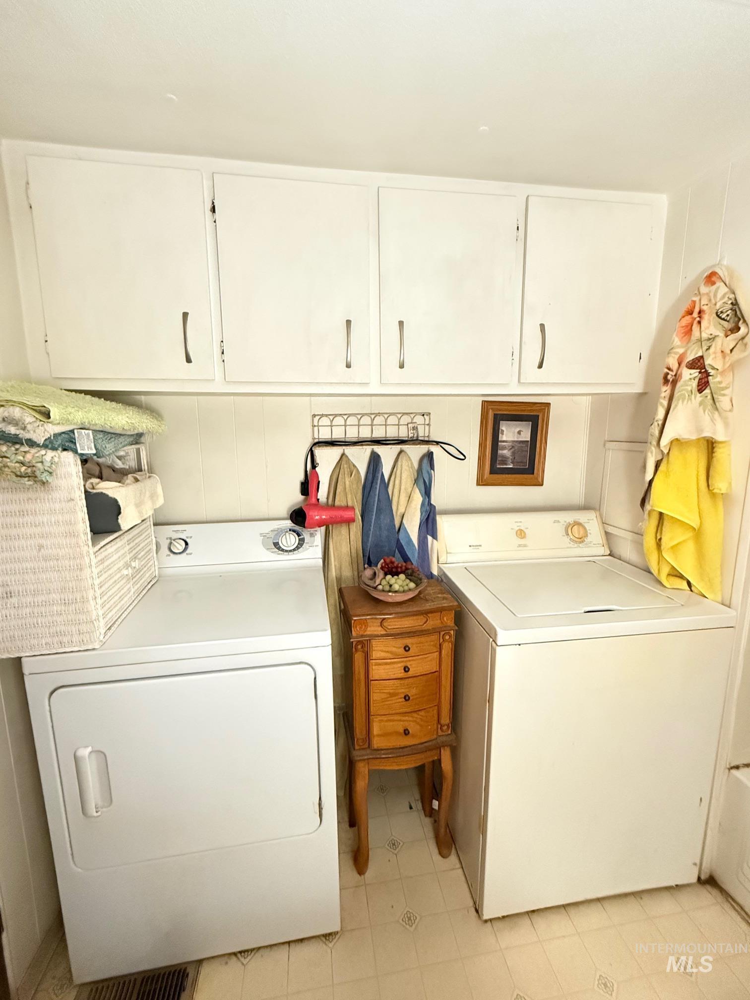 5742 Grangemont Road Orofino, ID 83544 - Photo 14 of 25 Dedicated laundry area featuring white upper cabinetry, a white dryer, and a white top-load washing machine