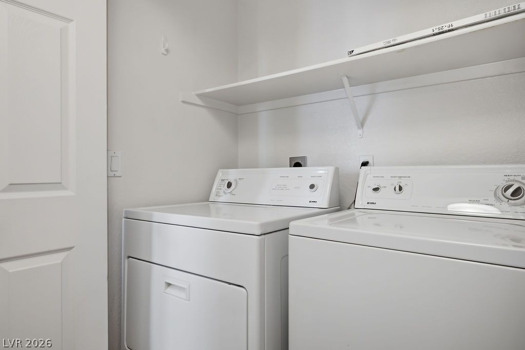 2201 Ramsgate Drive, Unit 514 Henderson, NV 89074 - Photo 14 of 28 A well-appointed utility area features a washer and dryer beneath convenient overhead shelving.