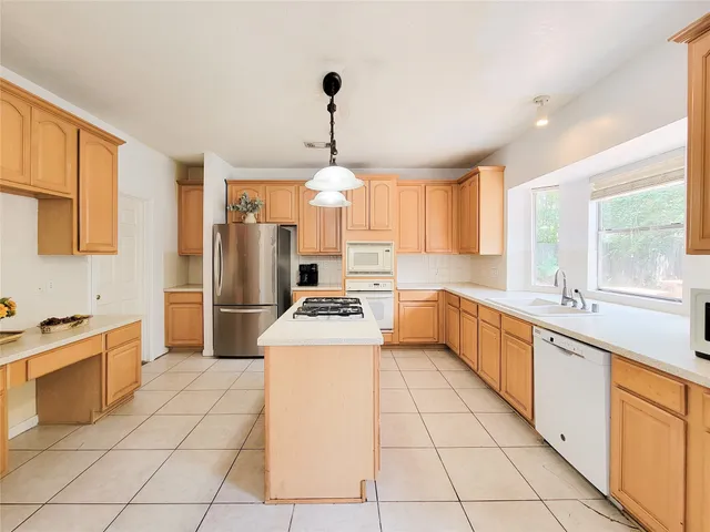 a kitchen with a sink a stove a refrigerator and cabinets