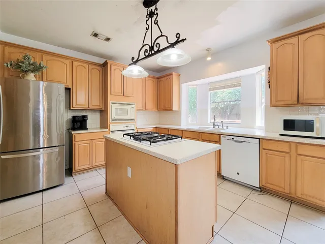 a kitchen with cabinets stainless steel appliances and window