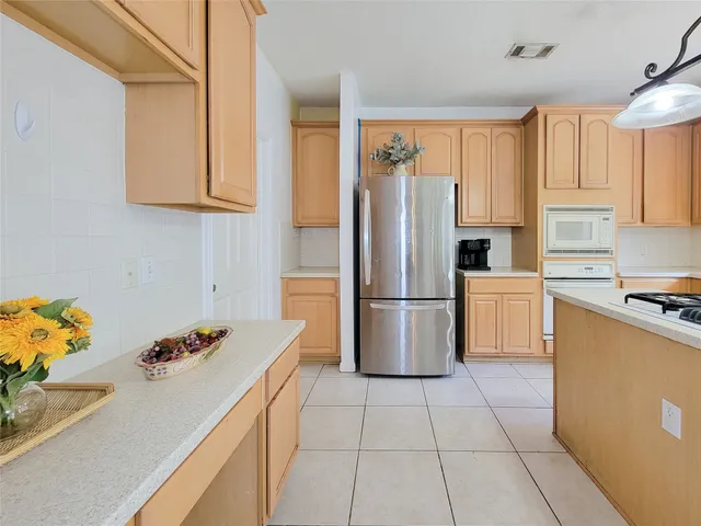 a kitchen with stainless steel appliances granite countertop a refrigerator sink and white cabinets
