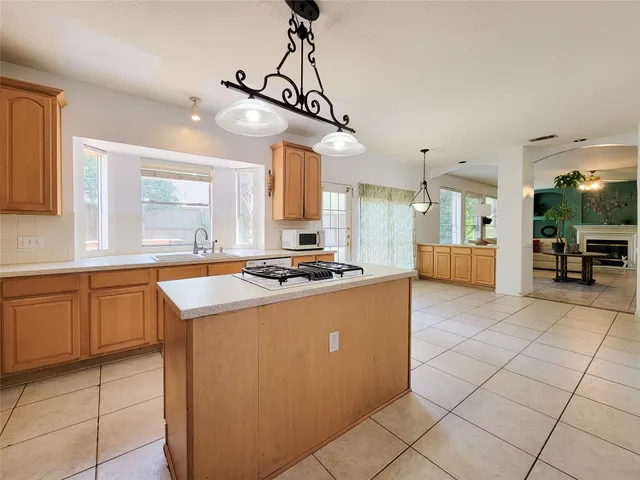 a large kitchen with stainless steel appliances granite countertop a large stove a sink a dining table and chairs