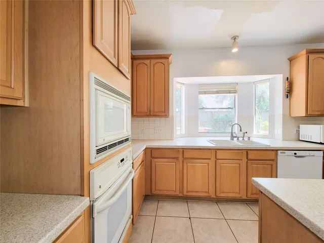 a large kitchen with cabinets and a window