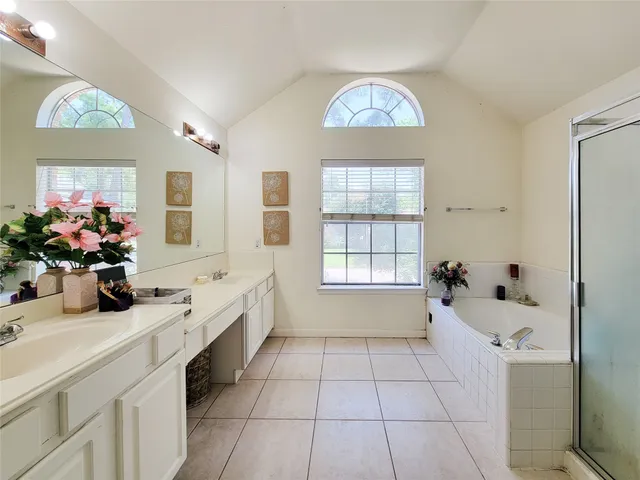 a bathroom with a tub sink and mirror