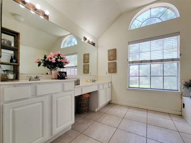 a spacious bathroom with a sink a vanity and a mirror