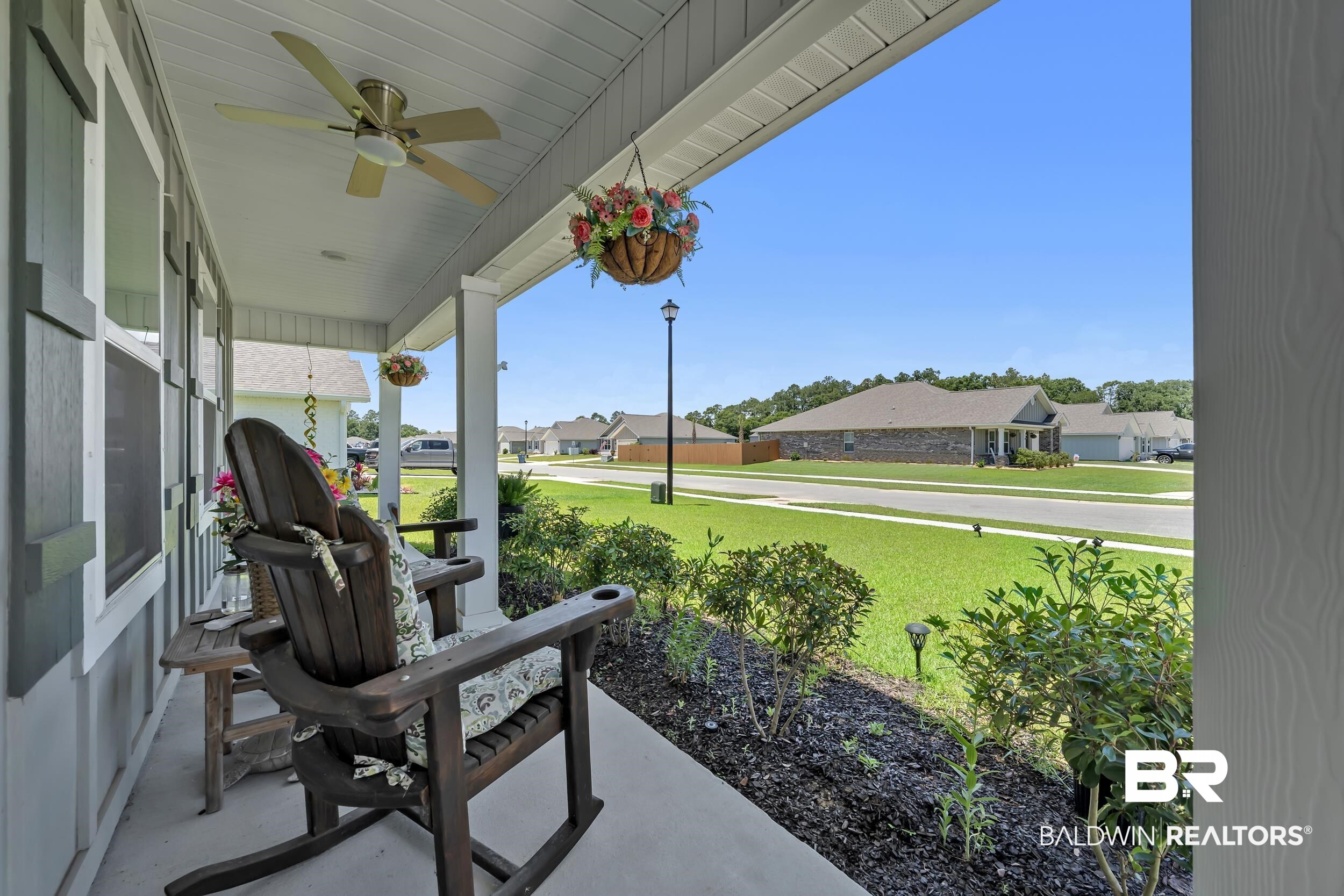 24271 Ringneck Loop Elberta, AL 36530 - Photo 20 of 44 Covered porch featuring a ceiling fan, white columns, and grey siding