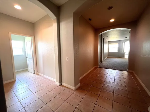 a view of a hallway with wooden floor and a living room