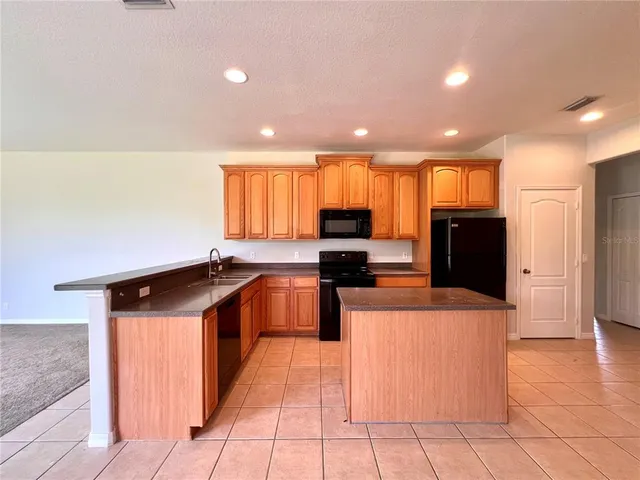 a kitchen with stainless steel appliances granite countertop a refrigerator and a stove