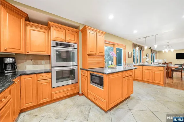 a kitchen with stainless steel appliances granite countertop a stove and more cabinets