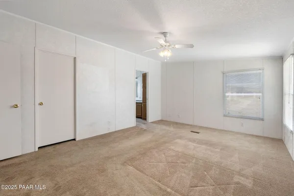 an empty room with chandelier fan