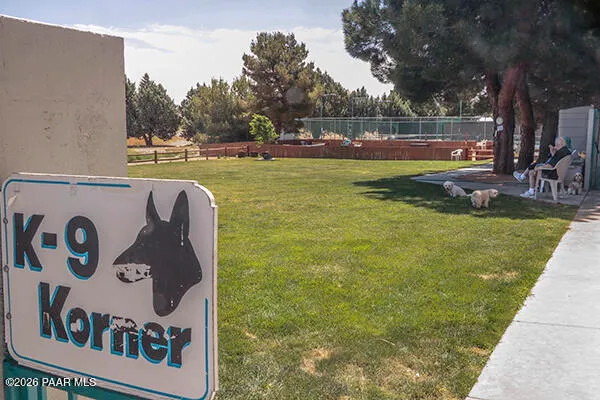a view of swimming pool with seating area and trees in the background
