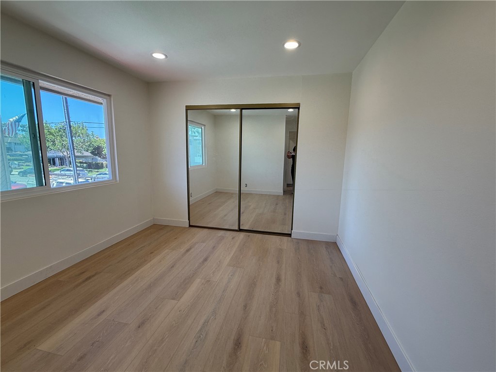 16752 Sims Lane, Unit A Huntington Beach, CA 92649 - Photo 6 of 8 an empty room with wooden floor and windows