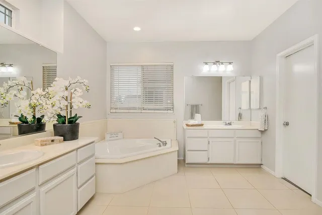 a bathroom with a tub sink and mirror