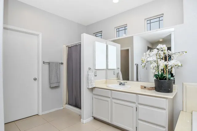 a bathroom with a double vanity sink mirror and shower