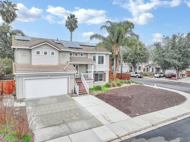 a view of a white house with a fountain and a yard