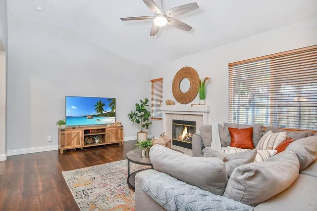 a living room with furniture a flat screen tv and a fireplace