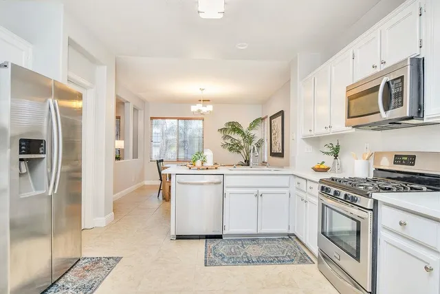 a kitchen with stainless steel appliances granite countertop a stove a sink and a refrigerator