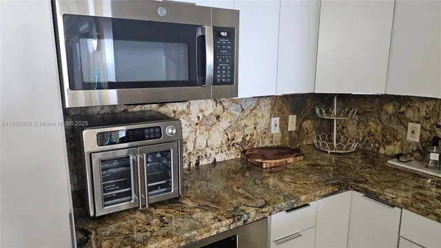 a kitchen with granite countertop a sink and a stove top oven