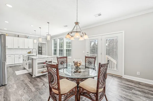 a dining room with furniture a chandelier and wooden floor