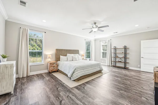 a spacious bedroom with a large bed a chandelier and a window
